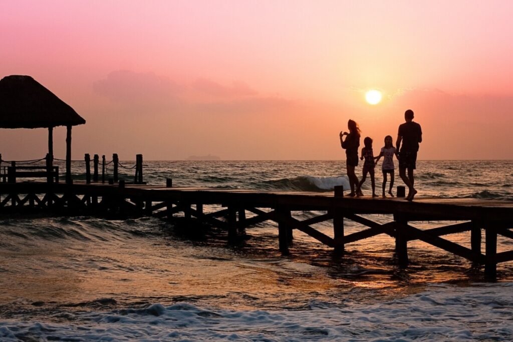 A family on a pier at sunset on holiday