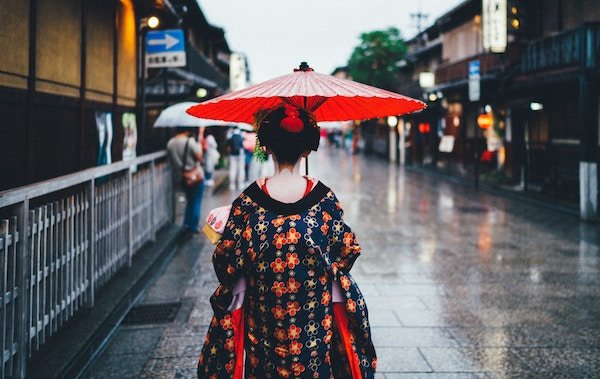 A Japanese woman with a red umbrella