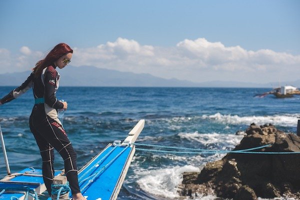 A woman stands on the edge of a boat