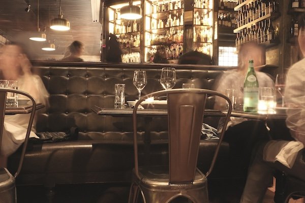 An empty table with fleeting people around it