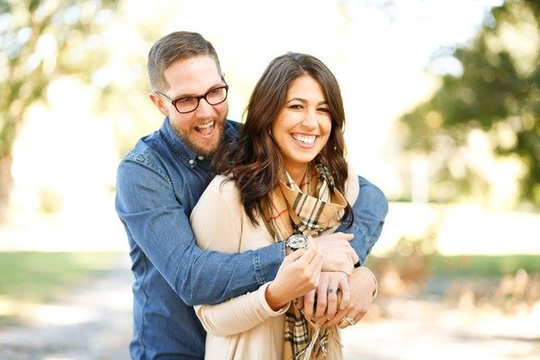 A man and a woman smiling after a proposal