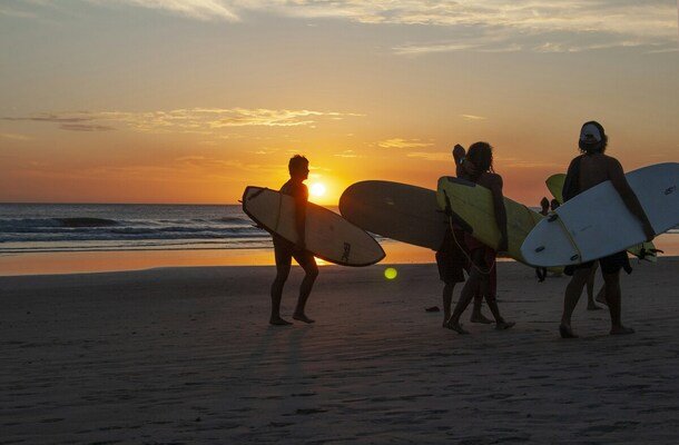 Surfers at sunset moment