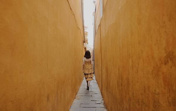 A woman walking in a narrow street