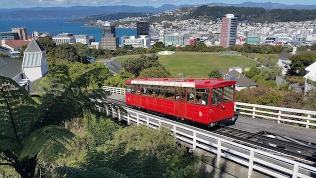 A red tram going down a hill