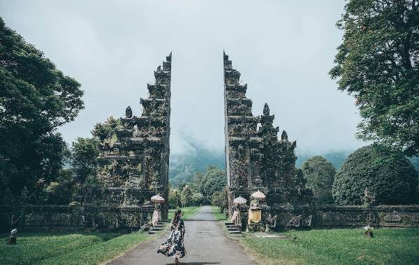 Temple in Bali with girl walking towards it