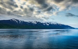 A view of snow capped mountains over icy water