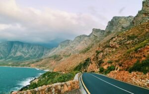 The road stretches forward next to the sea in Cape Town.