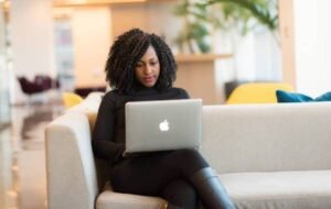 Woman working on a laptop in a modern coworking space, representing digital nomad lifestyle