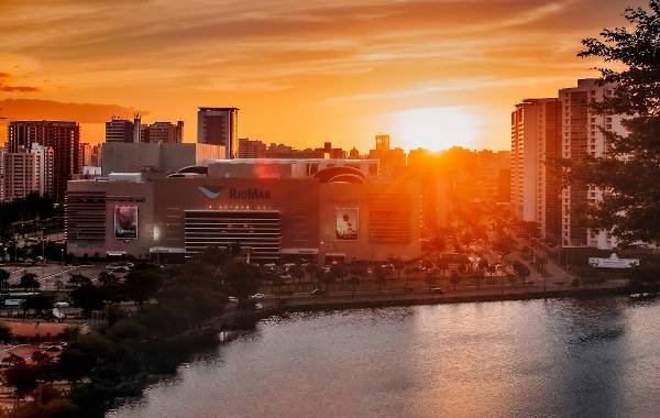 Urban skyline of Fortaleza, Brazil, featuring a sunset view over the city’s modern architecture and a nearby lake.