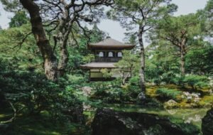 Zen garden with a traditional Japanese temple surrounded by lush greenery in Kyoto.