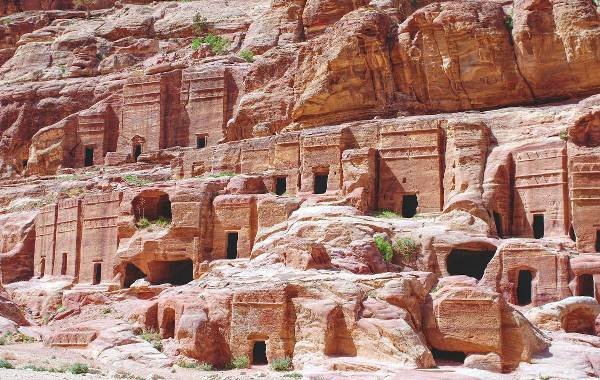 Ancient rock-cut architecture of Petra, Jordan, showcasing detailed facades carved into red sandstone cliffs.