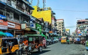 Bustling street scene in Phnom Penh, Cambodia with tuk-tuks and vibrant storefronts