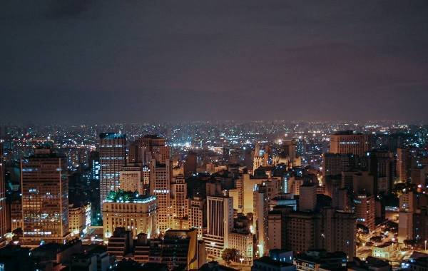 Night view of São Paulo, Brazil, showcasing a vibrant city skyline illuminated by city lights against a dark sky.