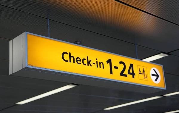 Yellow airport check-in sign for counters 1-24.