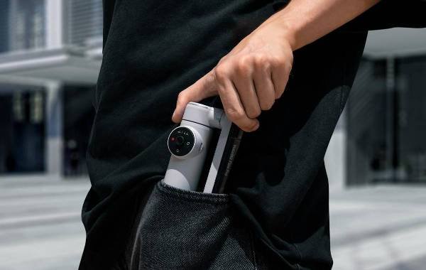 Person placing Insta360 Flow Pro camera into pocket, highlighting compact design