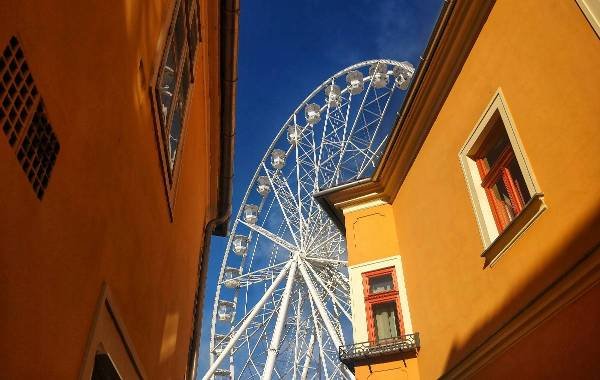 Ferris wheel between historic buildings in Gyor, Hungary on a sunny day