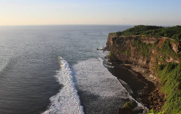 The cliffs of Uluwatu where you can paraglide in Bali with the shore below