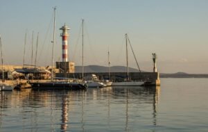 The dock of burgus with small boats and a lighthouse in the distance