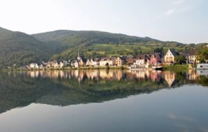 A castle looking over the lake. Vineyards are around the castle