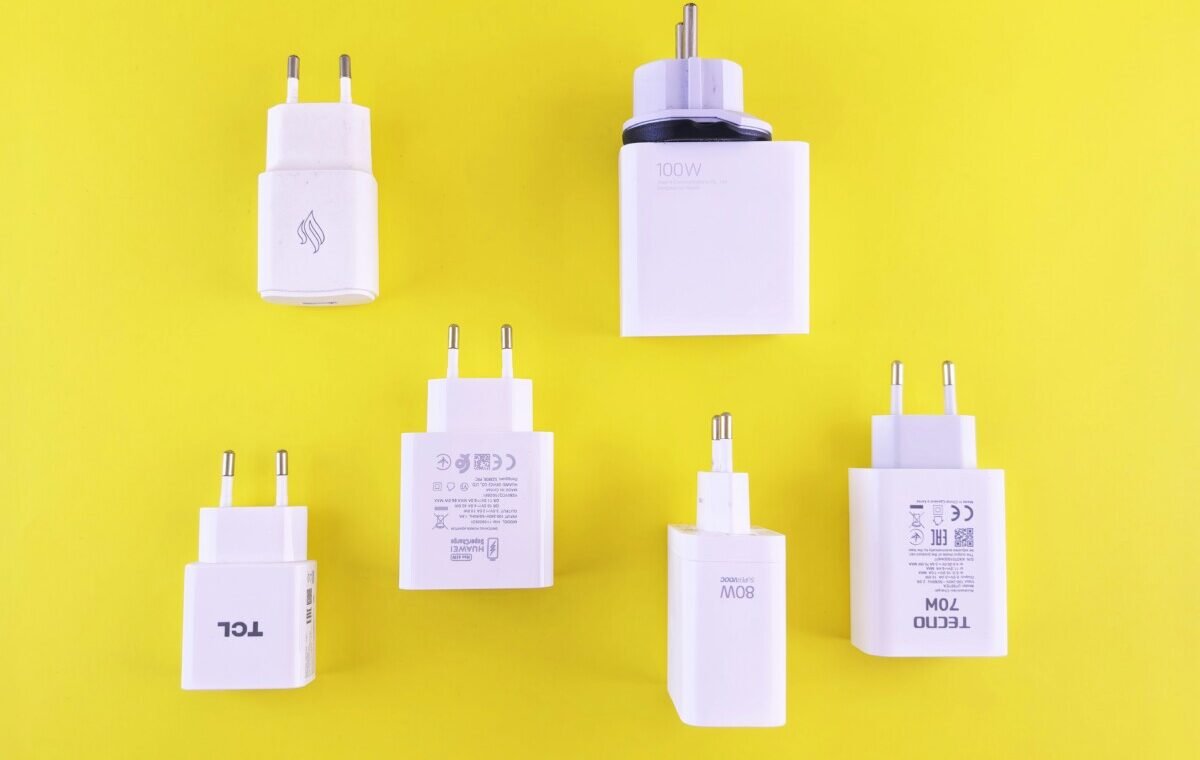 Assorted white USB Type-C chargers with varying wattages on a bright yellow background