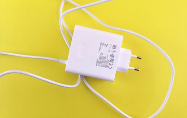 White Type-C charger with plug and cable on a yellow background, showcasing its design and details for tech enthusiasts