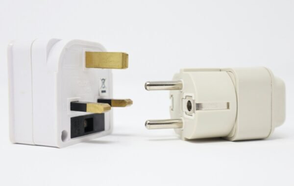 Type F plug connectors displayed side by side, featuring a three-prong design on the left and a two-pin adapter on the right, against a clean white background