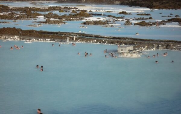 Soothing blue waters of the Blue Lagoon in Iceland, filled with bathers enjoying the geothermal spa amidst a rugged natural landscape