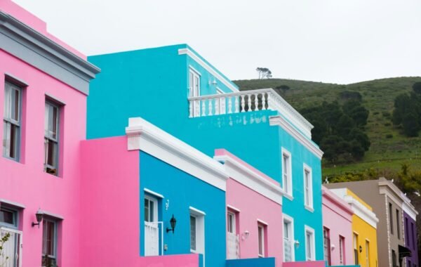 Colorful houses in Bo-Kaap, Cape Town, South Africa, showcasing vibrant pastel colors against a backdrop of green hills