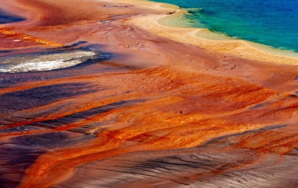 Vibrant colors of Grand Prismatic Spring in Yellowstone National Park showcase stunning thermal features, with bright orange, blue, and earthy tones merging around the spring's edges