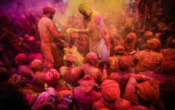 Vibrant scene from Holi festival in India, capturing a crowd joyfully celebrating with colorful powders, surrounded by festive atmosphere and traditional attire