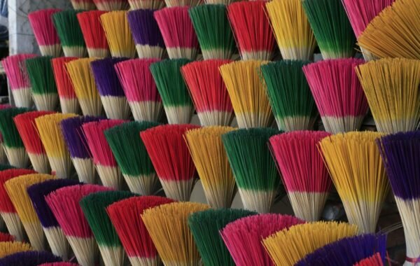 Colorful bundles of incense sticks arranged in vibrant patterns, showcasing a variety of hues including pink, green, yellow, and purple