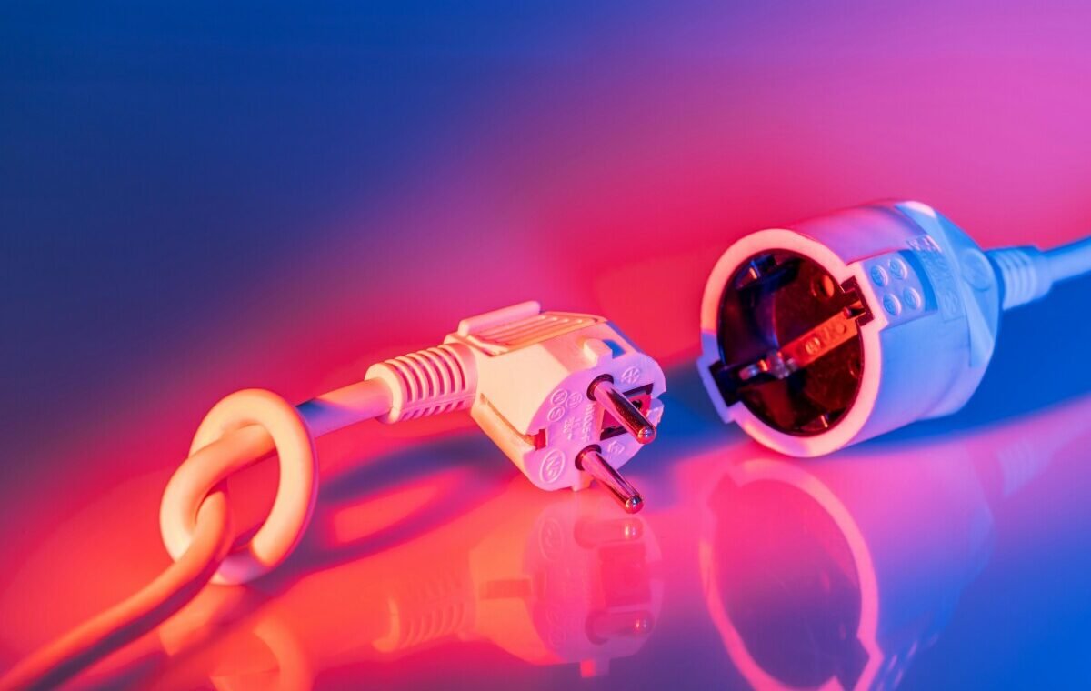 White electrical plug and socket with a colorful gradient background, showcasing a modern design